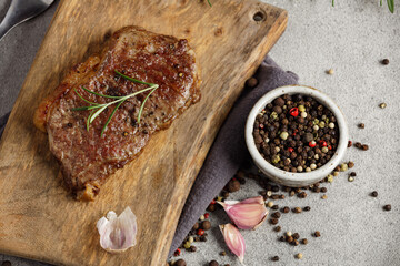 Grilled beef steak medium rare on wooden cutting board. Top view.