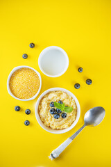 Corn porridge with fresh blueberries in a bowl