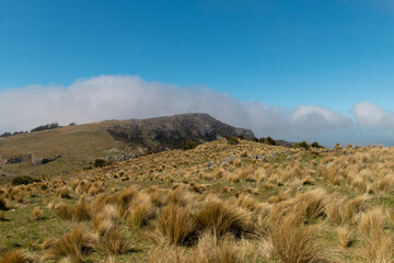 Grassy hill and blue sky at Port Hills, Christchurch, New Zealand.