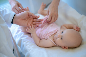 Fototapeta na wymiar Surgeon checking babys legs for dysplasia