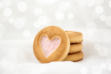 Sponge cookies with a heart and a white mug. Background for lovers on Valentine's Day