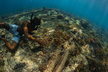 26 March 2019 near island Gilli, Indonesia. Young man exploring coral reef. Underwater sport and...