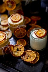 Vertical shot of homemade yogurt with dried orange slices on a rustic background