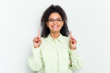 Young african american woman isolated indicates with both fore fingers up showing a blank space.