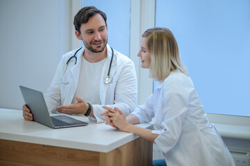 Two doctors sitting close and discussing something