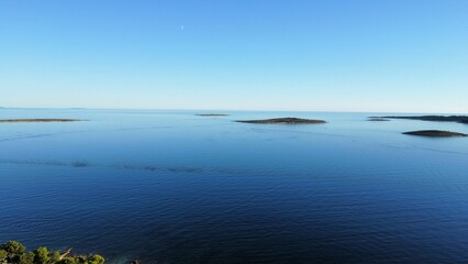 Panoramic view of the sea with little islands intertwining with the clear blue sky