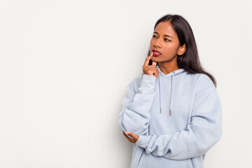 Young Indian woman isolated on white background looking sideways with doubtful and skeptical expression.