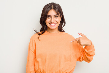 Young Indian woman isolated on white background person pointing by hand to a shirt copy space,...
