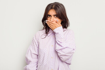 Young Indian woman isolated on white background covering mouth with hands looking worried.