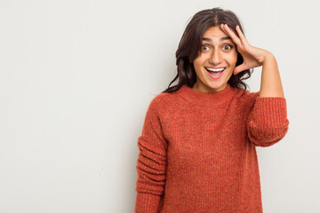 Young Indian woman isolated on white background shouts loud, keeps eyes opened and hands tense.