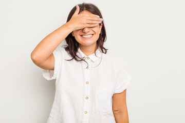 Young Indian woman isolated on white background covers eyes with hands, smiles broadly waiting for a surprise.