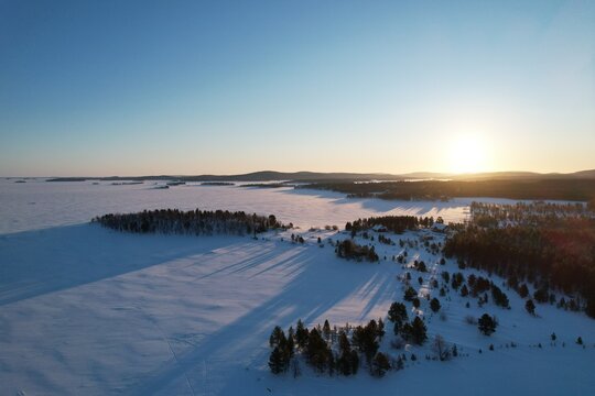 Sunrise with sun over frozen Inari Lake, Finland Lapland