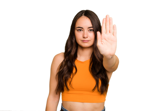 Young caucasian woman isolated on green chroma background standing with outstretched hand showing stop sign, preventing you.