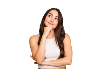 Young caucasian woman isolated on green chroma background thinking and looking up, being reflective, contemplating, having a fantasy.