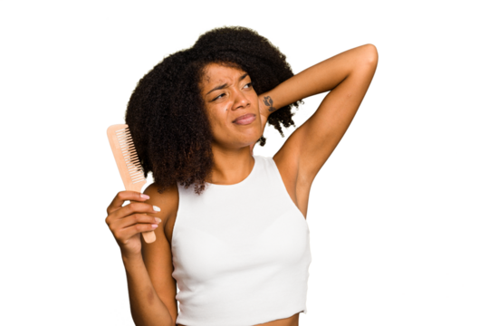 Young african american woman holding hair comb isolated touching back of head, thinking and making a choice.
