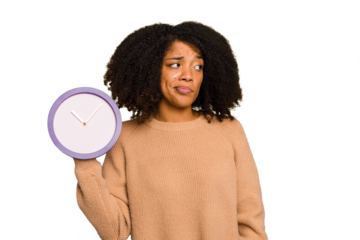 Young African American holding a clock isolated confused, feels doubtful and unsure.