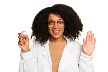 Young otorhinolaryngologist African american woman holding hearing aid isolated smiling cheerful showing number five with fingers.