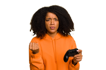 Young African American woman holding a game controller isolated showing fist to camera, aggressive facial expression.