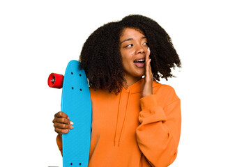 Young skater African American woman holding a little skate isolated is saying a secret hot braking...