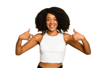 Young African American woman isolated surprised pointing with finger, smiling broadly.