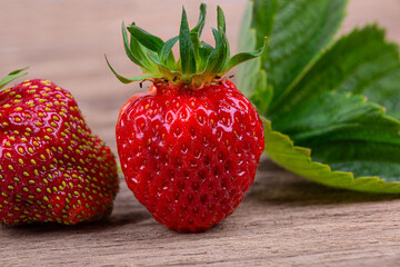 Strawberry berries close-up on a wooden background, macro photography