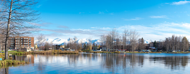 Panorama view lakeside apartment complex and vacation home, float planes on Lake Spenard with snow...