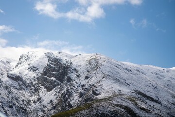 Scenic view of snow peak of mountain range under a blue cloudy sky