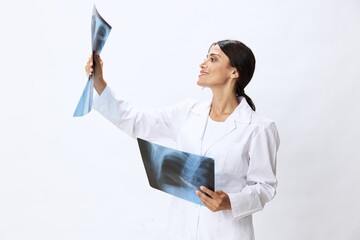 Woman doctor holding X-ray in robe on white background, consequences of covid-19, pneumonia and lung damage, concept of health 