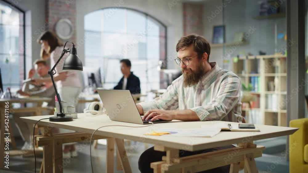 Aufkleber portrait of motivated caucasian young man with beard working on a laptop in office. male director pr