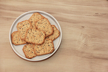 dry square diet crackers on a ceramic plate and a wooden background