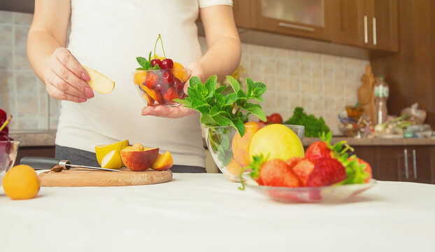 Midsection Of Woman Holding Fruits In Bowl