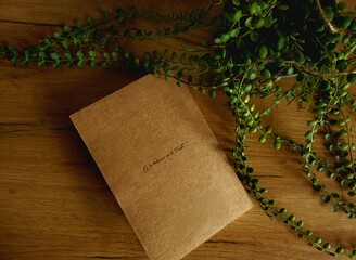 Kraft notebook on a wooden background, next to a flower pot