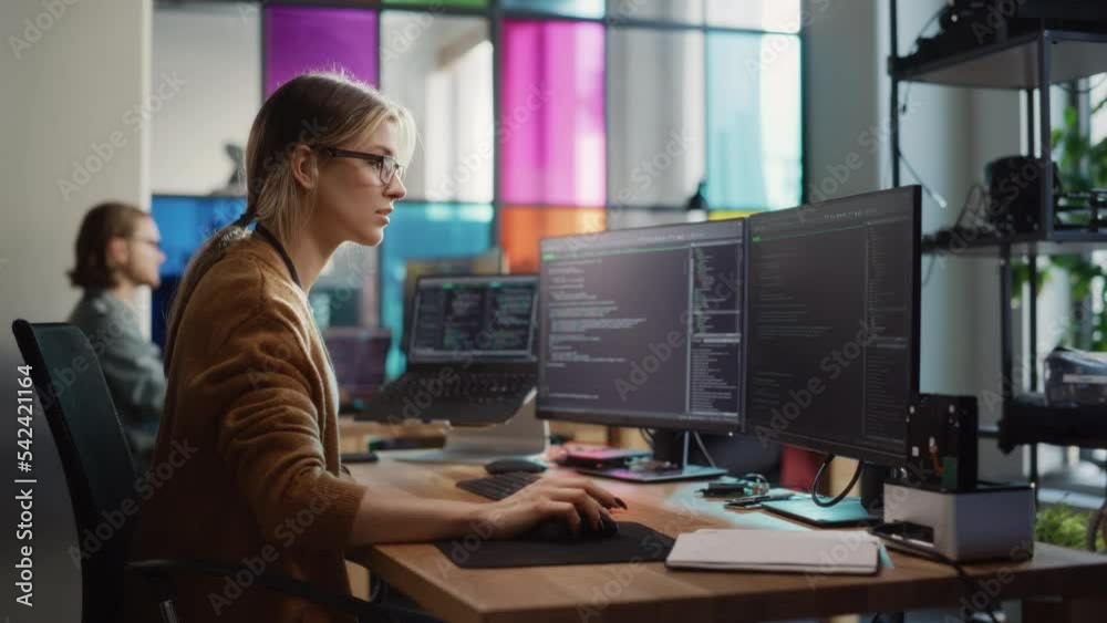Leinwandbilder Caucasian Woman Coding on Desktop PC and Laptop Setup With Multiple Displays in Spacious Office. Female Junior Software Engineer Working on New Sprint of Mobile Application Development For Start-up.