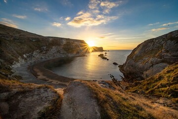 Beautiful shot of a lake coast surrounded by cliffs during sunset