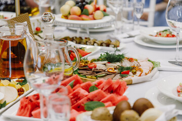 Serving a festive table in a restaurant, catering, snacks, salads, watermelon and canapes on the table