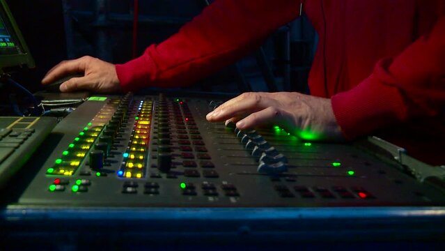 sound engineer's hands on the sound console during operation