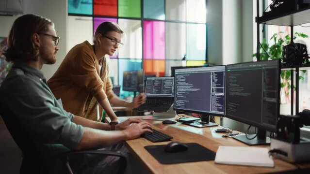 Female Data Scientist and Male Developer Improving Code on Desktop Computer in Stylish Office. Caucasian Man And Woman Creating Service as a Software Platform for Innovative Technological Start-Up.