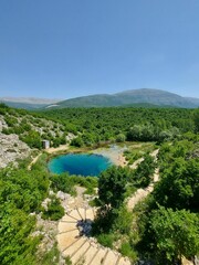 Fototapeta na wymiar Emerald lake in Zelenogorye, Crimea, surrounded by the hills under the clear sky