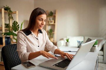 Portrait of young woman working on a laptop in the office