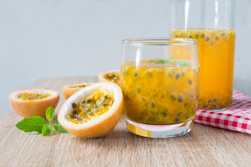 Fresh Passion fruit juice by fresh ingredients with slice passion fruit on wooden table.