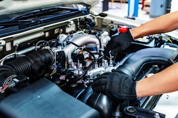 Fototapeta na wymiar Auto mechanic working with open car hood in garage. Car repair service.