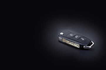 A car key with central locking system on black background