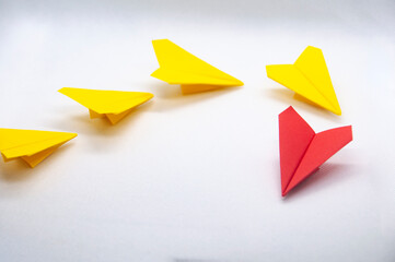 Red paper plane origami leading yellow planes on white background. Leadership concept.