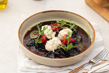 Portion of dried beet salad with stracciatella cheese and herbs