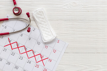 Women health. Stethoscope and calendar with red days of menstruation period
