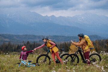 Young family with little daughter at bicycles, in the middle of autumn nature.Concept of a healthy...