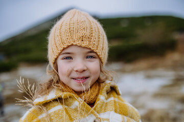 Portrait of little girl during autumn hike in mountains.