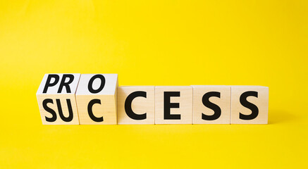 Obraz premium Process and Success symbol. Turned cubes with words success and process. Beautiful yellow background. Business and process and success concept. Copy space