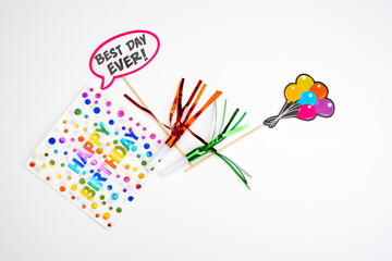Obraz premium Birthday party background. Invitation card, party supplies, birthday whistles, party glasses and hats, gift boxes, flags and napkins.