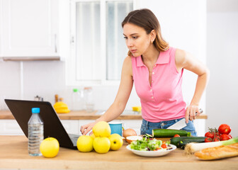 Obraz na płótnie Canvas Housewife preparing food in kitchen at home